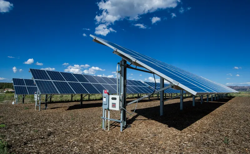 Un champ de panneaux photovoltaïques sous un ciel partiellement nuageux